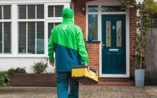 A person in an Ovo Energy uniform walks towards a house.