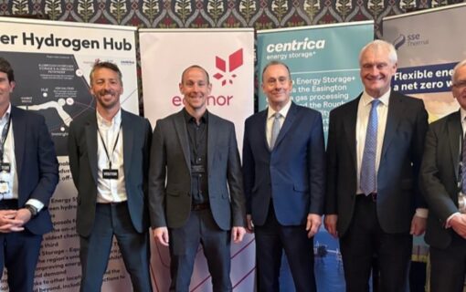 A group of white men stand in front of proposals for the Humber Hydrogen Hub