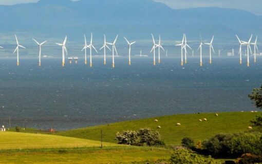 Offshore wind turbines behind green hills