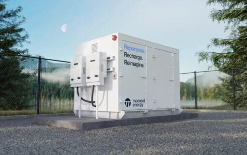 a battery energy storage unit painted white and bearing the moment energy logo stands alone and outside