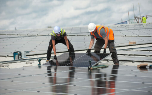 Workers install solar panels at a community energy site