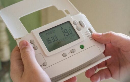 A close up of hands holding a smart meter