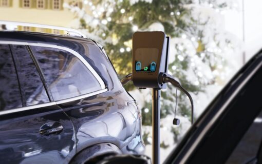 A car plugged into a free standing EV charger
