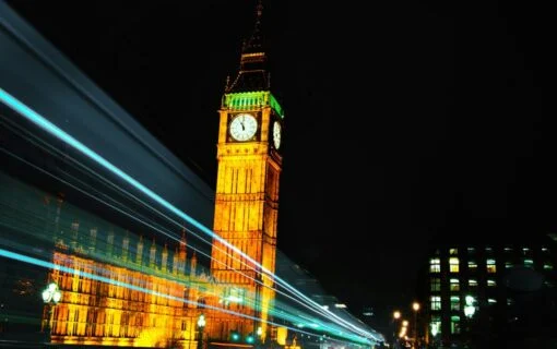 the tower of london at night as car headlights zoom past