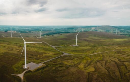 distant wind turbines across green hills under a grey sky
