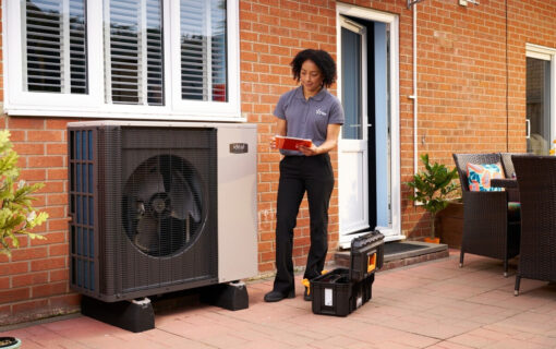 woman stands by a home heat pump
