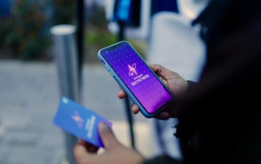 A person looks to their phone and card, both with the Octopus Electroverse logo on