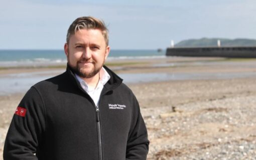 a white man stands on a beach