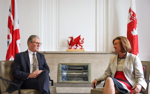 Prime Minister Kier Starmer and Welsh First Minister Eluned Morgan sit opposite each other in chairs in a white room in front of UK and Welsh flags