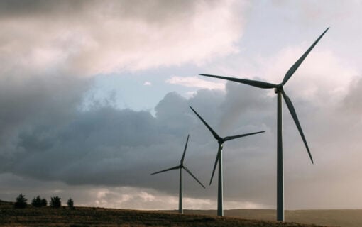 three onshore wind turbines against a overcast sky