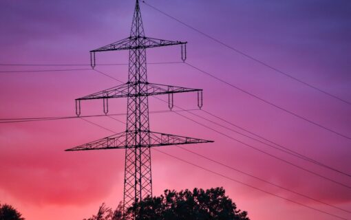 A pylon at sunset. The sky is red, pink and purple.