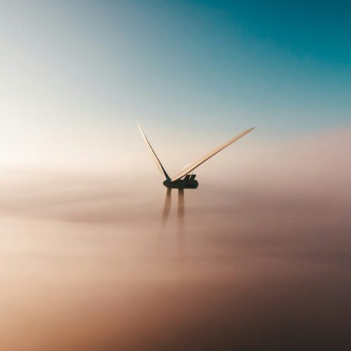 the top of a wind turbine surrounded by mist