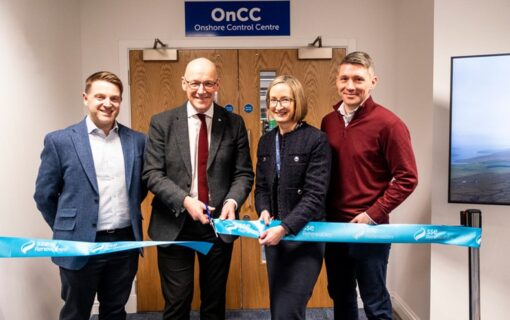 A GROUP OF PEOPLE CUT A RIBBON