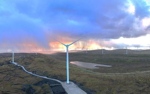 Image of a wind turbine with sun setting in the background.