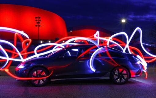 a car in a dark room with swirling neon waves of light surrounding it